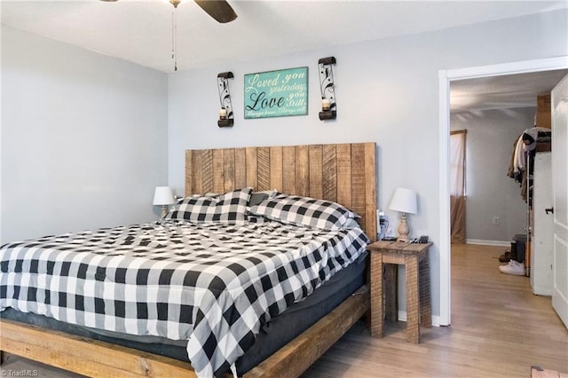 bedroom featuring baseboards, a ceiling fan, and wood finished floors