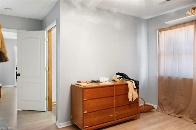 interior space with light wood finished floors, visible vents, and baseboards