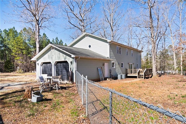 exterior space with a garage, fence, and a wooden deck