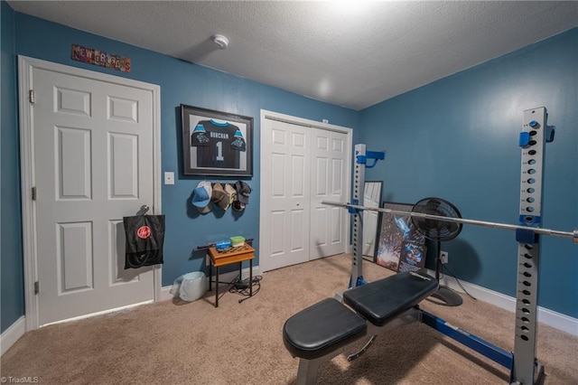 exercise area with carpet floors and a textured ceiling