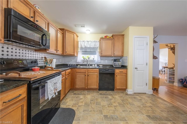 kitchen with black appliances, decorative backsplash, and sink