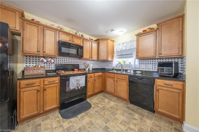 kitchen featuring black appliances, backsplash, dark stone countertops, and sink