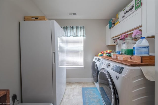 laundry area featuring washer and clothes dryer and cabinets