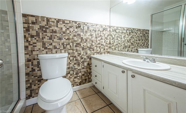 bathroom featuring tile walls, vanity, a shower with shower door, tile patterned floors, and toilet