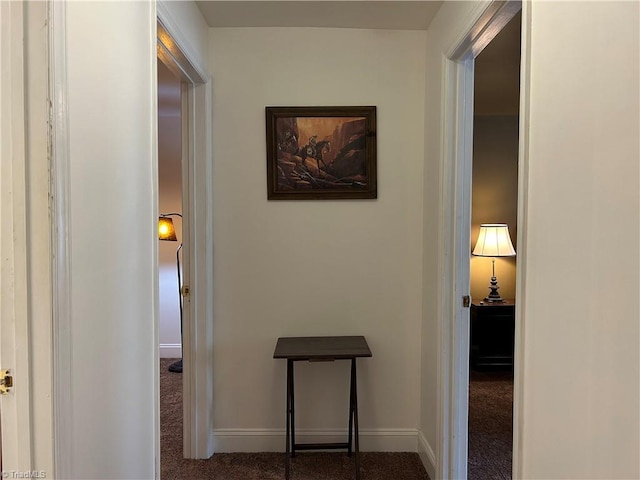 hallway with baseboards and carpet flooring