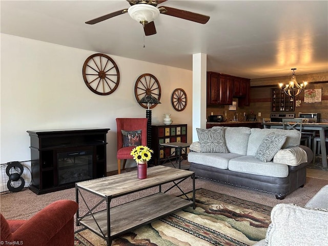 carpeted living room with a chandelier, ceiling fan, and a glass covered fireplace