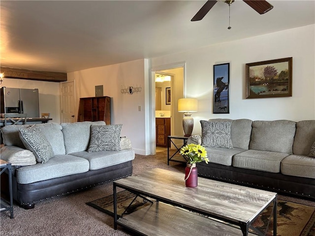 carpeted living area featuring ceiling fan and baseboards