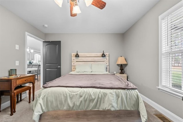 carpeted bedroom with visible vents, ceiling fan, and baseboards