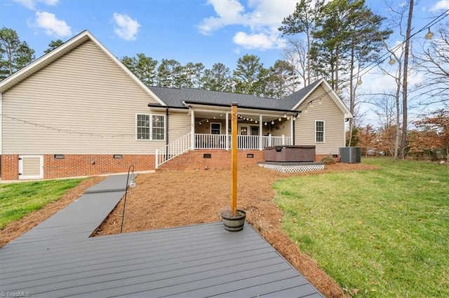 rear view of house featuring crawl space, a hot tub, central AC unit, and a yard