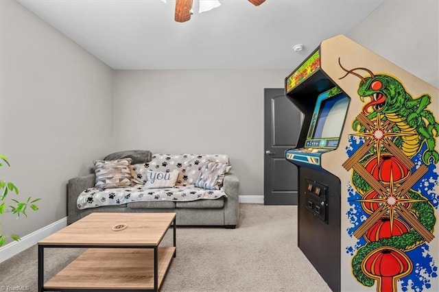 carpeted living area featuring baseboards and a ceiling fan