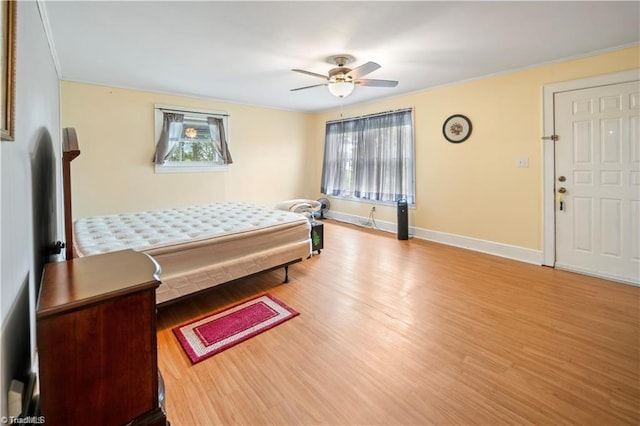 bedroom with multiple windows, ceiling fan, baseboards, and wood finished floors