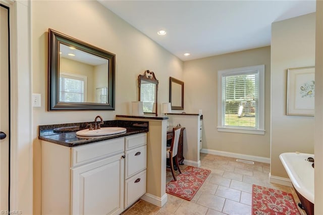 bathroom with vanity, tile patterned floors, and a bathing tub