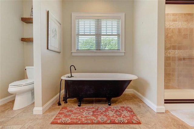 bathroom with a washtub, tile patterned floors, and toilet