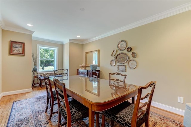 dining area featuring crown molding and light wood-type flooring