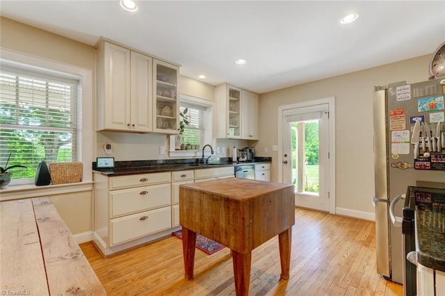 kitchen with butcher block countertops, light hardwood / wood-style floors, appliances with stainless steel finishes, and sink