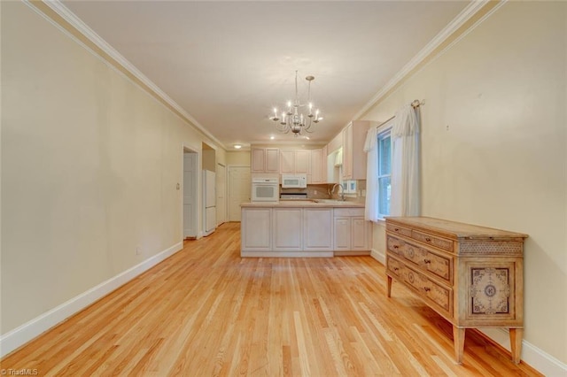 kitchen featuring white appliances, a notable chandelier, ornamental molding, and sink