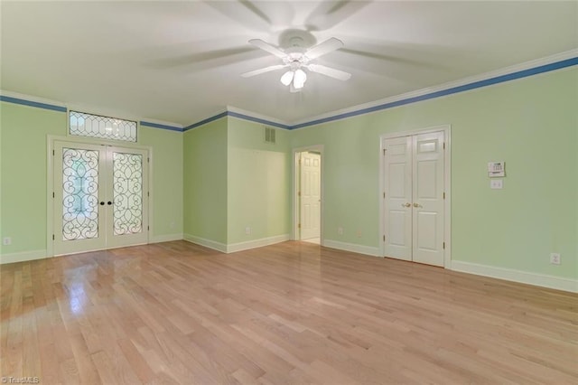 empty room featuring ceiling fan, french doors, crown molding, and light hardwood / wood-style flooring