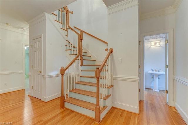 stairway featuring hardwood / wood-style floors and crown molding