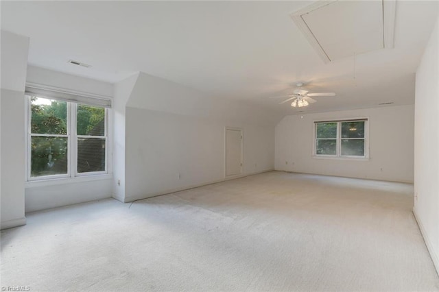 carpeted spare room with ceiling fan and vaulted ceiling