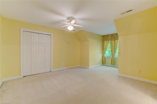 bonus room with ceiling fan and carpet