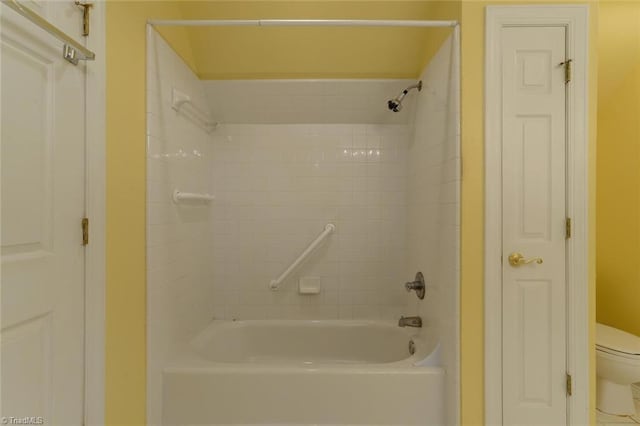 bathroom featuring toilet and tiled shower / bath combo