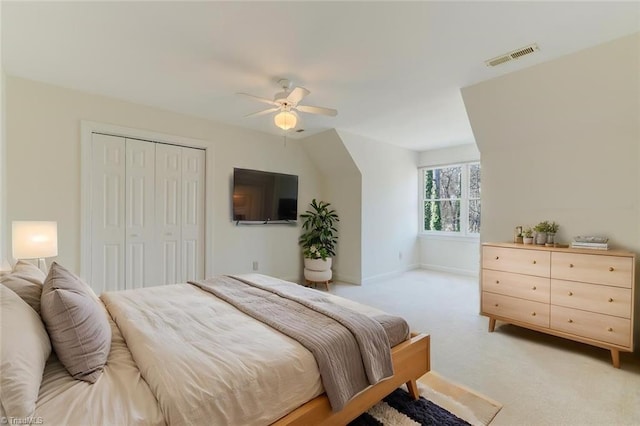 carpeted bedroom featuring ceiling fan and a closet