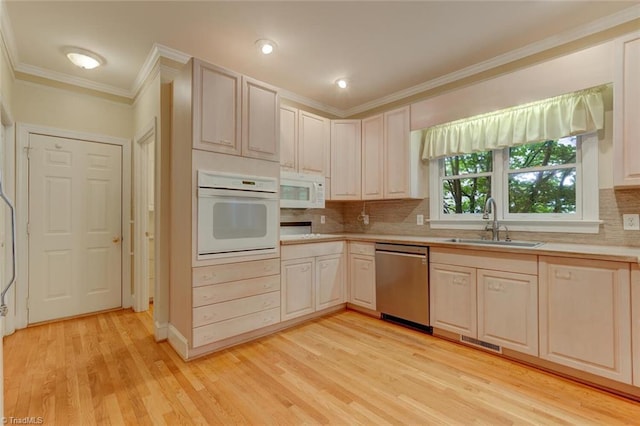 kitchen featuring white appliances, light hardwood / wood-style floors, backsplash, and sink