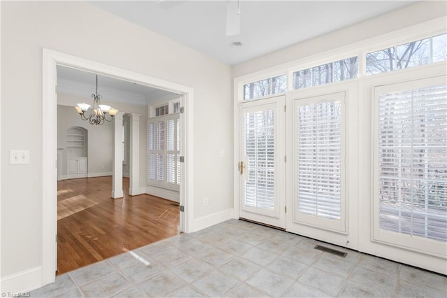 interior space featuring visible vents, plenty of natural light, ceiling fan with notable chandelier, and baseboards