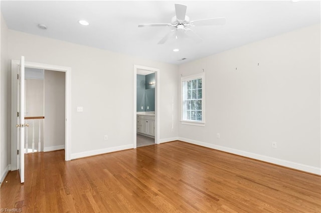 unfurnished bedroom featuring baseboards, recessed lighting, ceiling fan, light wood-style floors, and connected bathroom