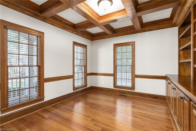 unfurnished room featuring baseboards, plenty of natural light, coffered ceiling, and light wood finished floors