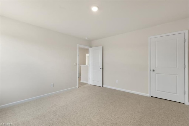 spare room featuring light colored carpet