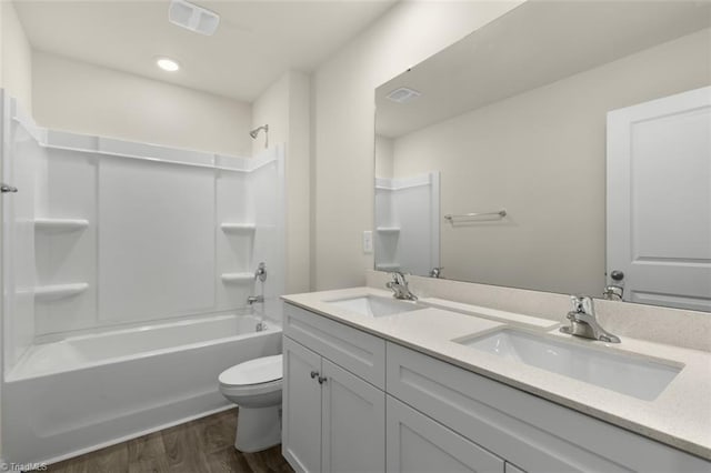 full bathroom featuring shower / tub combination, hardwood / wood-style floors, toilet, and vanity