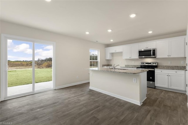 kitchen with appliances with stainless steel finishes, white cabinetry, and a kitchen island with sink