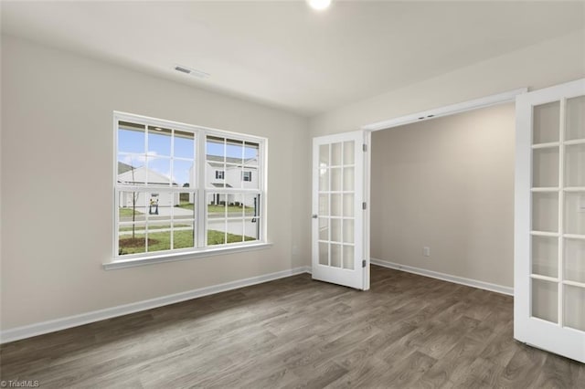 unfurnished room featuring french doors and hardwood / wood-style flooring