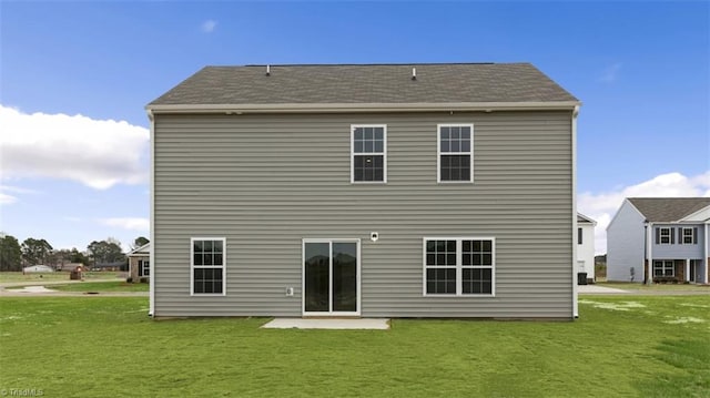 rear view of house featuring a lawn and a patio