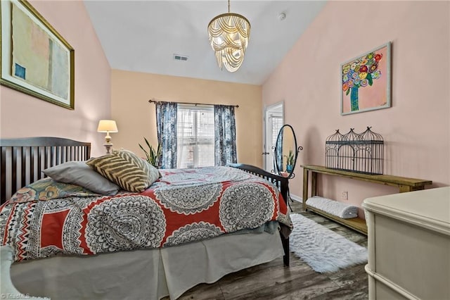 bedroom with lofted ceiling, wood finished floors, and visible vents