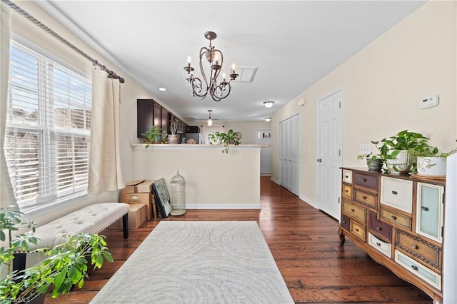 dining area featuring dark wood-type flooring, a wealth of natural light, a chandelier, and baseboards