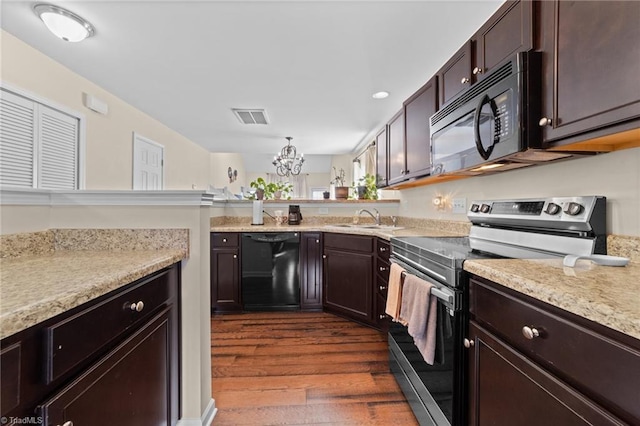 kitchen with a sink, visible vents, dark brown cabinets, dark wood-style floors, and black appliances