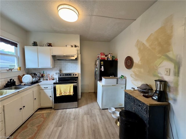 kitchen featuring white cabinetry, tasteful backsplash, a textured ceiling, stainless steel appliances, and light hardwood / wood-style floors