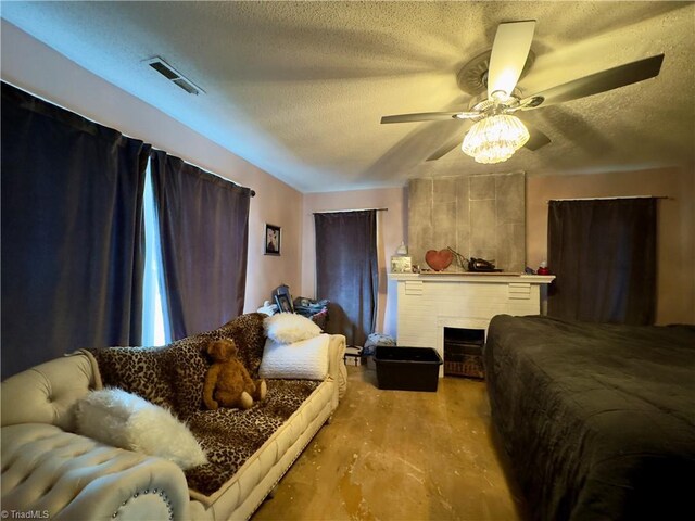 bedroom featuring ceiling fan, a fireplace, light hardwood / wood-style floors, and a textured ceiling