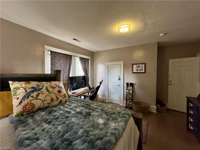 bedroom with dark wood-type flooring and a textured ceiling