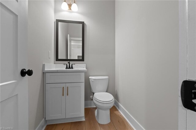 bathroom featuring vanity, wood-type flooring, and toilet