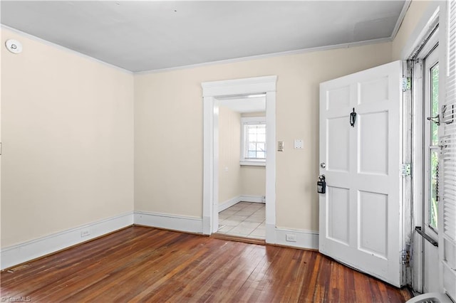 foyer entrance with ornamental molding, hardwood / wood-style floors, and baseboards