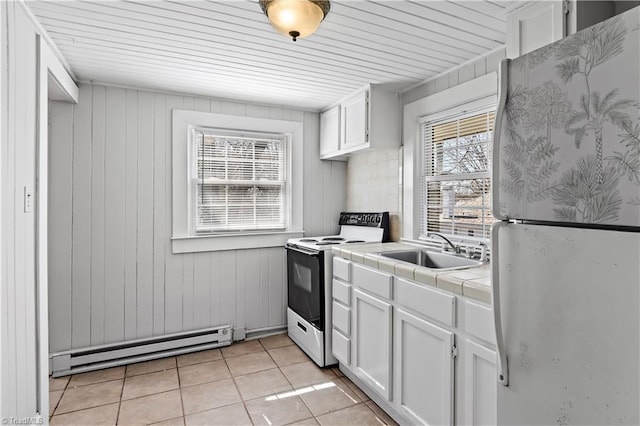 kitchen featuring tile countertops, a baseboard radiator, electric range oven, freestanding refrigerator, and a sink