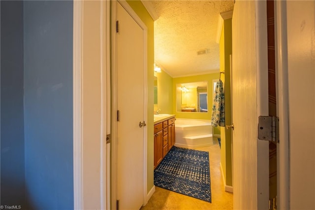 corridor with sink, crown molding, and a textured ceiling