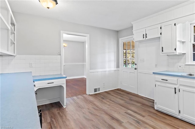 kitchen featuring tasteful backsplash, white cabinetry, and light hardwood / wood-style flooring