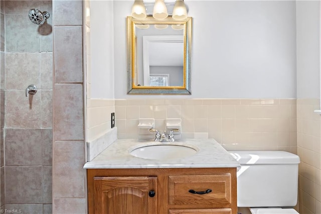 bathroom featuring vanity, toilet, and tile walls