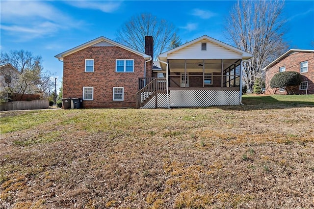 back of property with a sunroom and a lawn