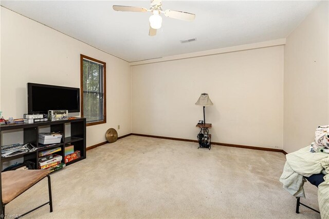 sitting room with ceiling fan and carpet flooring