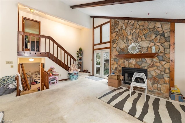 carpeted living room featuring a fireplace, beamed ceiling, and high vaulted ceiling